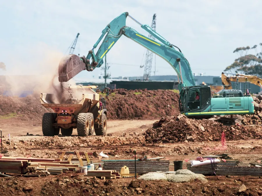 Bagger belädt einen Kipper auf einer Baustelle